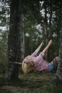 Young woman on swing in forest